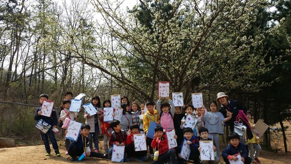 2014년 4월 7일, 서울신은초 1학년 <열매반> 어린이들이 지양산에서 풀꽃 공부를 하면서 학습지에 채집한 식물들을 들어 보이면서 기념 사진을 찍고 있다.(출처 : 김광철)