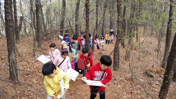 아직 이른 봄이라 숲의 나무들의 잎이 많이 나오지 않은 숲길을 봄맞이 학습을 위하여 열심히 올라가고 있다.(출처 : 김광철)