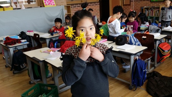 2014년 4월 초 신은초 화단에서 개나리 가지에 달린 꽃을 가지고 꽃배 놀이 하기에 앞서서 꽃을 들어 자랑하고 있는 하진이(출처 : 김광철)