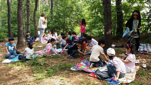 2014년 1학년 아이들이 지양산 숲에서 감각게임을 하고 나서 맛있는 점심을 먹고 있다.(출처 : 김광철)
