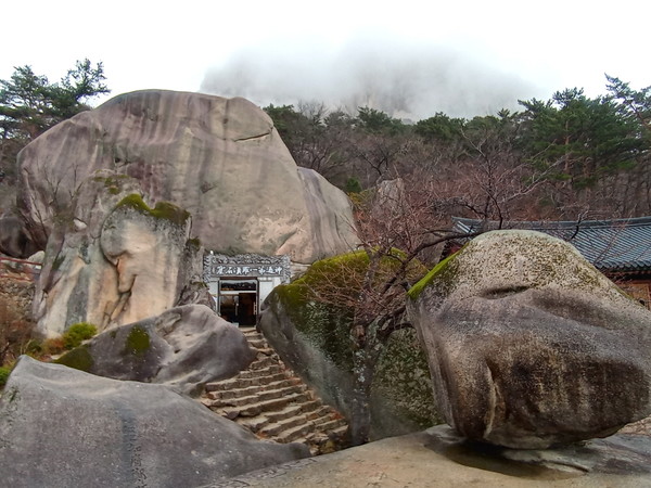 석굴과 흔들바위, 석굴 뒤로 구름에 가려진 울산바위가 보인다. 