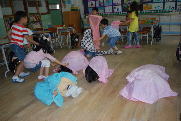 다들 누에고치가 되어 보자기 속에서 며칠의 시간을 보낸다는 멘트에 맞춰 누에고치 속의 번데기 모습들을 하고 있는 귀여운 아이들이랍니다.(제공 : 김광철)