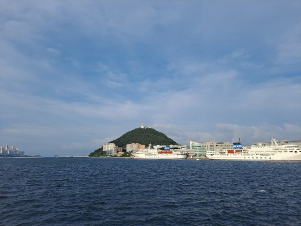 바다 멀리 왼편에 보이는 것은 용호동 이기대 아파트이다(출처 : 하성환) 사진 오른쪽은 해양대학교가 있는 섬 ,조도와 해양대 실습선  <한바다호>와 <한나라호>이다.