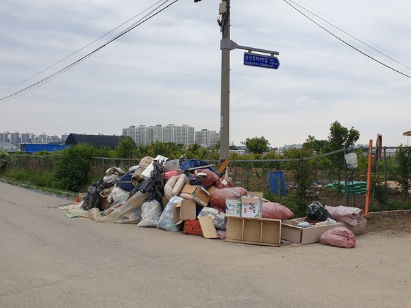 도로변에 적치된 불법 쓰레기(경기도 고양시 송산로 334번길에서)
