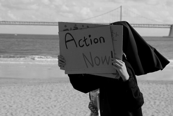 한 수도자가 광안리 해변에서 '지금 당장 행동'이라는 피켓을 들고 걷고 있다. ©장영식