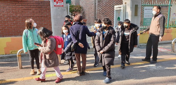 아이들의 인사를 받으며 하교 지도를 하고 있는 교사의 모습(특정 기사와 직접적인 관련은 없는 사진임)