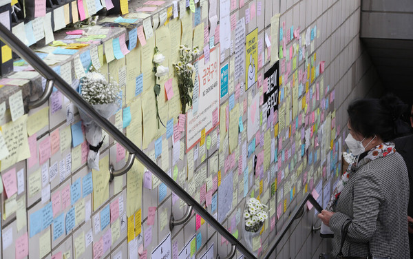 7일 오후 서울 용산구 이태원역 1번 출구에 붙은 추모의 글귀들을 시민들이 바라보고 있다. 신소영 기자 viator@hani.co.kr