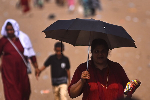 5월부터 아시아에 폭염이 이어지고 있는 가운데 지난 14일 인도 첸나이는 낮 온도가 40.7도에 이르렀다. 한 여성이 햇볕이 내리쬐는 거리를 우산을 들고 걷고 있다. 첸나이/EPA 연합뉴스 / 출처 : 한겨레 2023-05-22