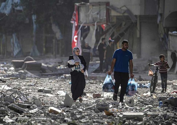 팔레스타인 주민들이 30일(현지시각) 이스라엘방위군(IDF)의 공습 이후 폐허로 변한 북부 가자시티의 텔알하와 지구에서 황망한 표정으로 거리를 지나고 있다. 텔알하와/EPA연합뉴스(사진출처: 한겨레신문))