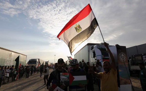 31일 가자지구와 이집트 사이 국경 라파흐 검문소에서 비정부기구 관계자들이 이집트와 팔레스타인 국기를 들고 있다. EPA 연합뉴스/사진출처: 한겨레신문)