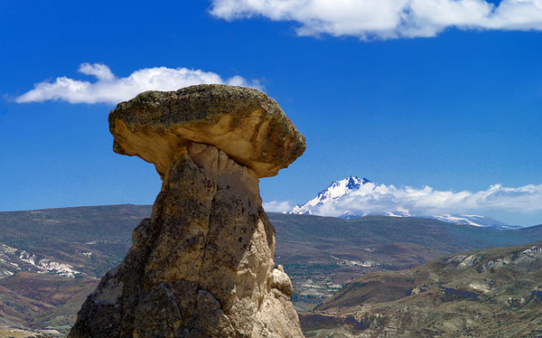 세 미녀 바위와 멀리 눈 덮힌 에르지에스 화산(사진 출처 : https://commons.wikimedia.org/wiki/File:%C3%9C%C3%A7_G%C3%BCzeller_-_Cappadocia_-_Kapadokya.jpg)