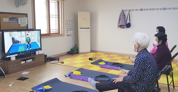 충남도립대 작업치료학과가 학교 울타리를 넘어 지역사회 통합돌봄체계에 녹아들어 제역할을 수행하고 있다. 주거환경개선사업에서는 안전손잡이 설치, 미끄럼방지물 설치 등 주민들이 집 안에서 재활활동이 가능한 맞춤형 환경이 조성될 수 있도록 자문을 제공한다. 코로나19 때는 방문운동지원 사업이 중단되자 영상 교육 자료를 제작하고 경로당 등에 배포했다. 사진은 영상 교육 자료를 보고 재활운동을 따라하는 주민들의 모습.(사진제공 청양군)