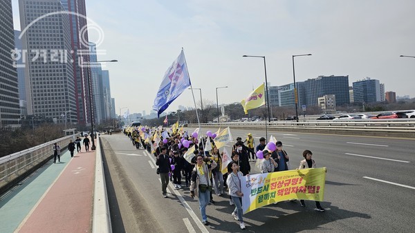 세월호참사 10주기 전국시민행진에 참석한 시민이 한강 마포대교를 지나고 있다.