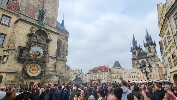 구시가지 광장에 모인 관광객. 특히 매 정시에 천문시계를 보려고 운집한다. 사진 우측은 틴 성모 마리아 교회, 중앙 붉은 지붕은 골츠킨스키 궁전