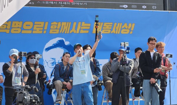 배경에 이재명 대표 얼굴이 반쯤 보인다.