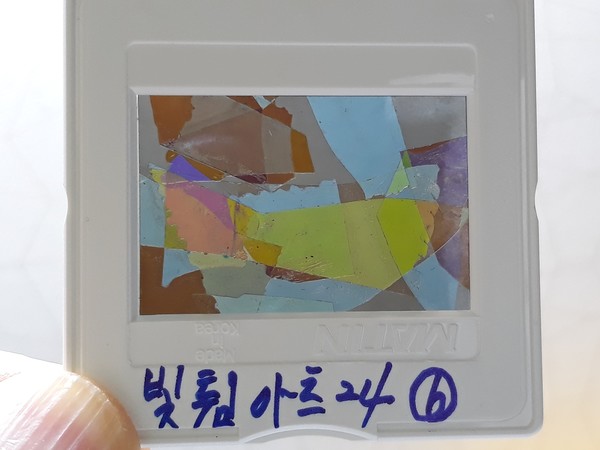 사진 김인수 / 2024년 오사카과학축제 빛튐 실험 1실험원리 “두 편광필름(손전화, 노트북 등) 사이에 복굴절 하는 물질(방해석, OPP 등)이 있을 때 광탄성(빛튐)이 나타난다.”를,슬라이드 마운트(33mm X 38mm)에 꼭 맞는 두 장의 편광필름 중 하나에 ‘OPP 테이프를 잘라 겹쳐 붙여’ 빛튐(광탄성) 아트(예술)를 완성.