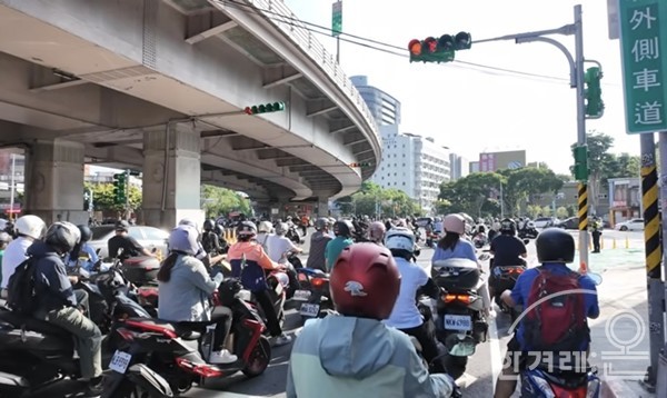 신호등에 빨간불이 들어오자 오토바이들이 차선 앞쪽으로 몰려옵니다.