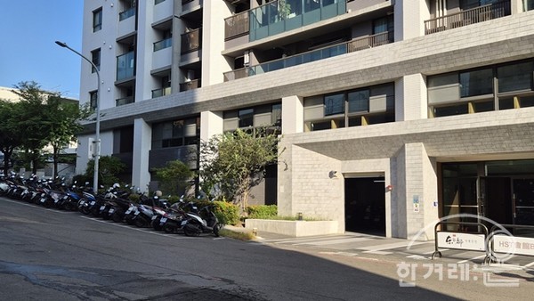 제가 살고 있는 15층 건물 앞쪽 입니다. 건물 외부에 오토바이 주차 공간이 있습니다. 누구에게나 개방된 무료 주차공간이고 셔터가 올라간 사각형 공간이 오토바이 주차장 출입구. 우측은 건물 입구이며 로비입니다. 가장 편한 1층 로비 옆에 오토바이 주차장 마련.