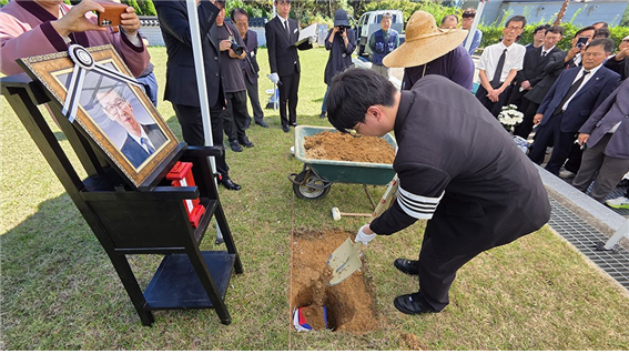 고 정해직 선생의 골호 위로 아들, 정광모 씨가 허토하고 있다. (사진 출처: 광주매일신문, 2025. 10. 12.)