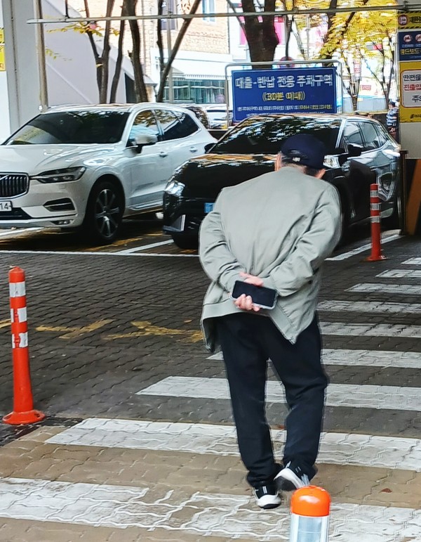  도서관 진입로를 걷고 있는 한 어르신의 뒷모습 (2025.11월 어느날)